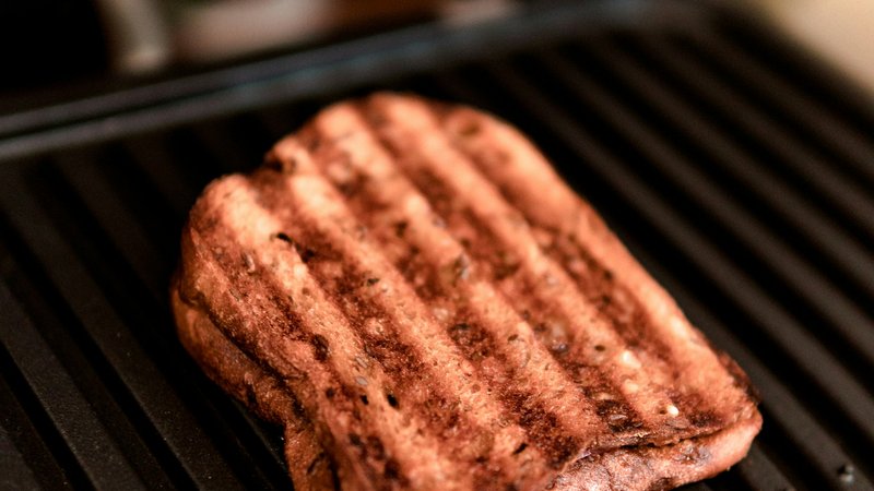 Close-up van geroosterd brood met grillstrepen op de platen van een contactgrill