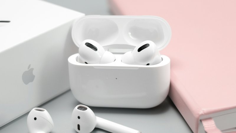 Open-ear oordopjes die om het oor klemmen naast een oplaadcase