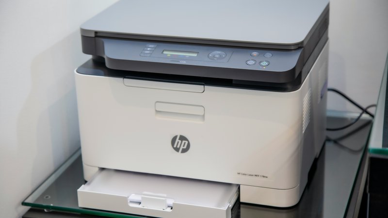 Compacte HP all-in-one laserprinter op een glazen bureau
